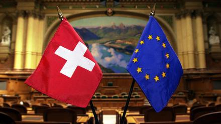 Fähnchen der EU und der Schweiz stehen im Nationalratssaal in Bern.