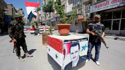 Regimetreu. Assad-Anhänger bewachen einen Kontrollpunkt in Damaskus.