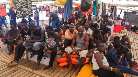 Migranten warten auf das Anlegen in einem sicheren Hafen an Bord des Rettungsschiffs „Open Arms“.