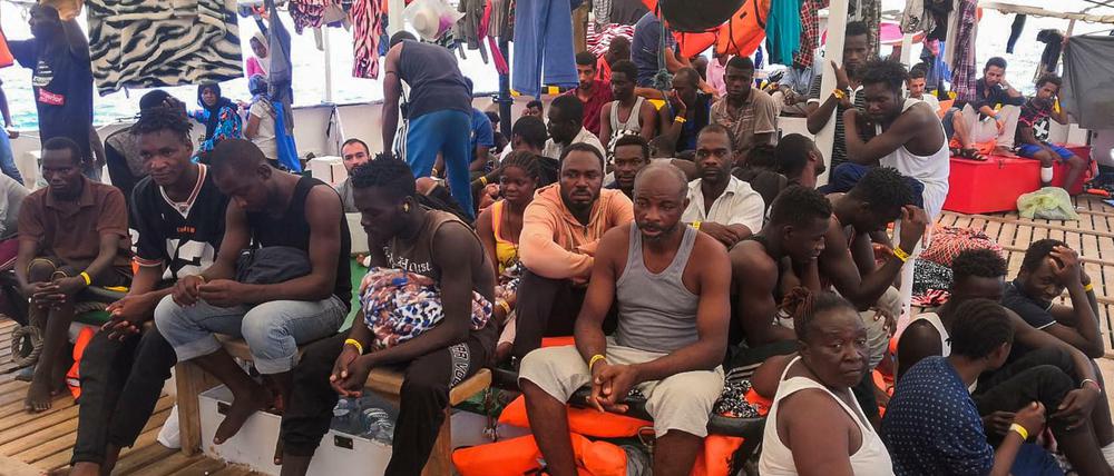 Migranten warten auf das Anlegen in einem sicheren Hafen an Bord des Rettungsschiffs „Open Arms“.