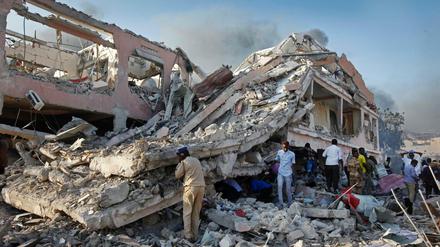 Menschen suchen nach einem Selbstmordanschlag am Ort der Explosion in Mogadischu nach Überlebenden.