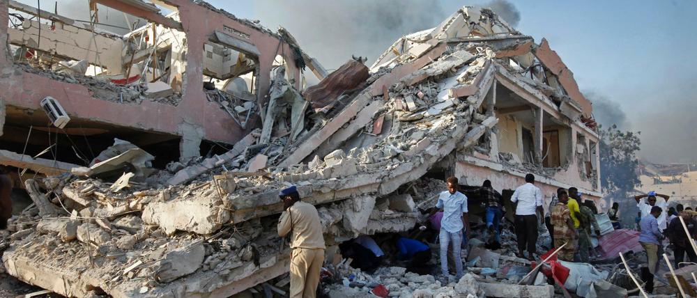 Menschen suchen nach einem Selbstmordanschlag am Ort der Explosion in Mogadischu nach Überlebenden.