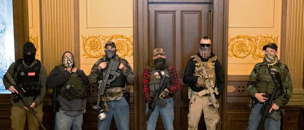Eine bewaffnete Gruppe steht vor dem Büro des Gouverneurs im besetzten Parlamentsgebäude in Lansing, Michigan. 