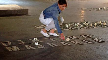 Während einer Zeremonie in der Holocaust Gedenkstätte Yad Vashem in Jerusalem legt eine Frau eine Blume nieder.