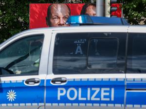 Ein Streifenwagen der sächsischen Polizei fährt an einem Wahlplakat der SPD mit dem Foto von Bundeskanzler Scholz vorbei (Symbolbild).