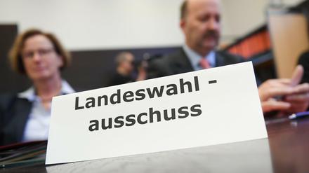 Mitglieder des Landeswahlausschusses sitzen im Sitzungssaal des hessischen Innenministeriums.
