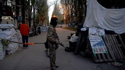 Ein prorussischer Separatist zwischen Barrikaden außerhalb eines von Millizen besetzten Gebäude der ukrainischen Sicherheitskräfte.