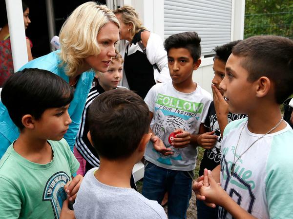 Bundesfamilienministerin Manuela Schwesig unterhält sich am 20.08.2015 in Heidelberg in einer Flüchtlingsunterkunft mit Kindern. 