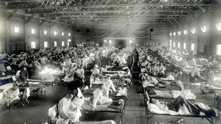 Patienten, die an der Spanischen Grippe erkrankt sind, liegen im Jahr 1918 in Betten eines Notfallkrankenhauses in Kansas (USA) 