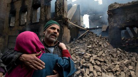 Eine Frau tröstet einen Verwandten, nachdem sein Haus im von Indien kontrollierten Kaschmir zerstört wurde. 