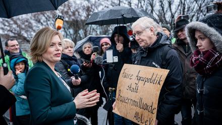 Landwirtschaftsminister Julia Klöckner (CDU) spricht mit Demonstranten, die einen Wandel in der Agrarpolitik fordern.