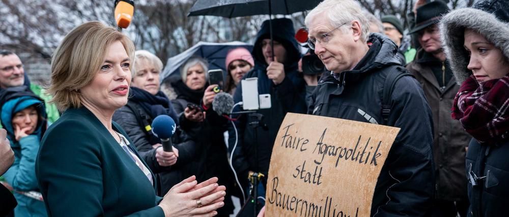 Landwirtschaftsminister Julia Klöckner (CDU) spricht mit Demonstranten, die einen Wandel in der Agrarpolitik fordern.