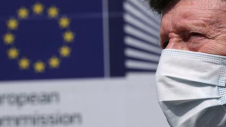 Mann mit einer Gesichtsmaske vor dem Sitz der EU-Kommission in Brüssel 