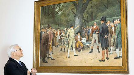 Er blickt zu ihnen auf - zurück. Der Bundespräsident vor einem Gemälde aus seinem Amtssitz Schloss Bellevue. Es zeigt den Jakobinerclub von Landau.