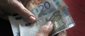 Eine 83-jährige Frau hält verschiedene Euronoten in der Hand.
