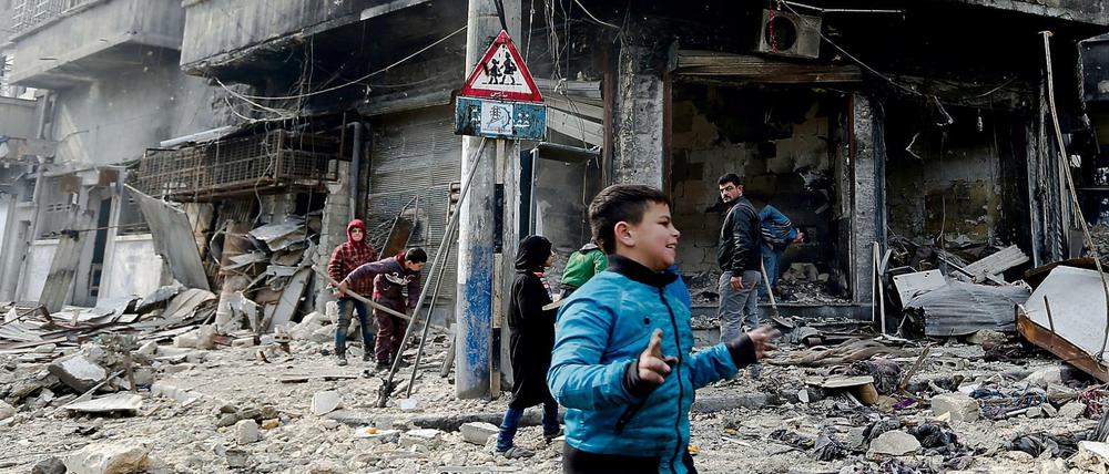 Kinder laufen am durch den schwer beschädigten Bezirk Bustan al-Qasr in Ost-Aleppo. 