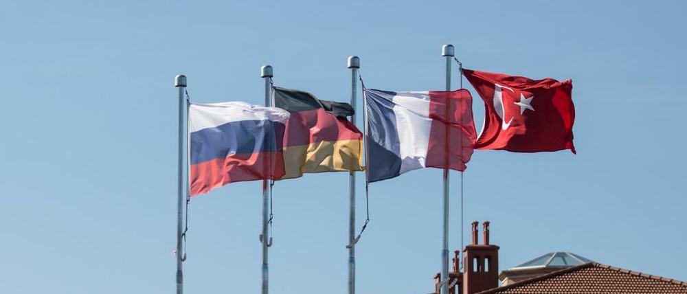 Die Flaggen von Russland (l-r), Deutschland, Frankreich und der Türkei wehen über dem Veranstaltungsort des Vierer-Gipfels zur Zukunft Syriens.