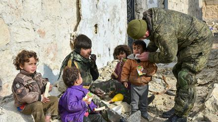Das undatierte Handout des russischen Verteidigungsministeriums zeigt nach russischen Angaben einen Soldaten der russischen Armee, der in Aleppo Saft an Kinder verteilt.