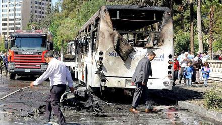 Zeichen der Zerstörung. Ein ausgebrannter Bus steht am Straßenrand in Damaskus. 