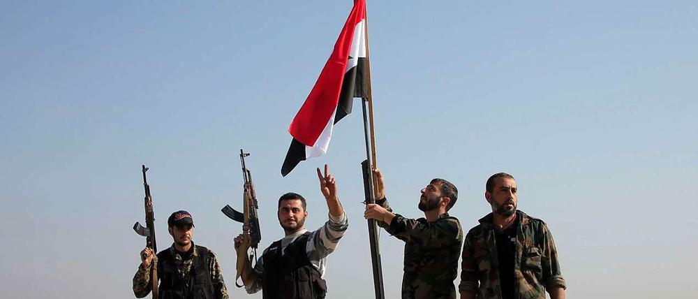 Gefolgsleute des syrischen Machthabers Assad hissen die Flagge. Für Assad geht es vor allem um Machterhalt.