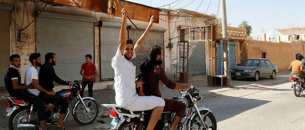 Anhänger der IS-Milizen feiern die Eroberung des Militärflughafens von Al-Tabka im Osten Syriens.