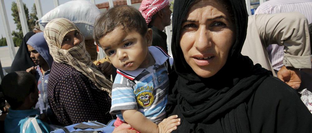 Weg vom Krieg. Eine Syrerin mit ihrem Kind an der türkisch-syrischen Grenze.