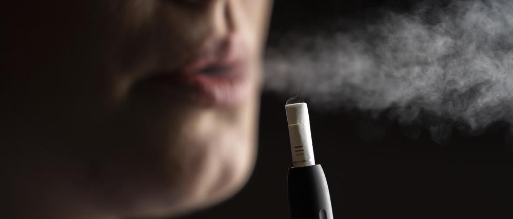 Eine Frau konsumiert einen Tabakstick. Künftig sollen die  Sticks keine „charakteristischen Aromen“ mehr enthalten.