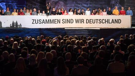 Gäste und Mitwirkende singen bei der zentralen Feier zum Tag der Deutschen Einheit in Mainz (Rheinland-Pfalz) nach dem Festakt in der Rheingoldhalle die Nationalhymne.