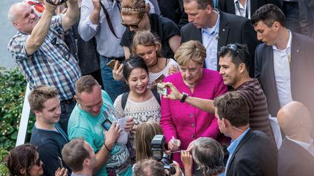 Bundeskanzlerin Angela Merkel (CDU) begrüßt Besucher beim Tag der Offenen Tür der Bundesregierung.