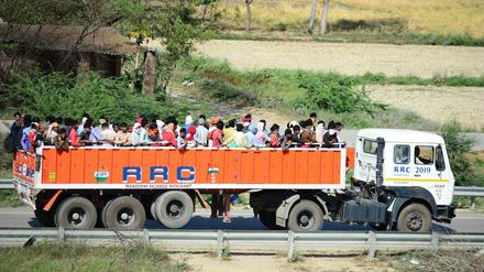 Inder versuchen auf einem Lastwagen ihre Heimatdörfer zu erreichen.