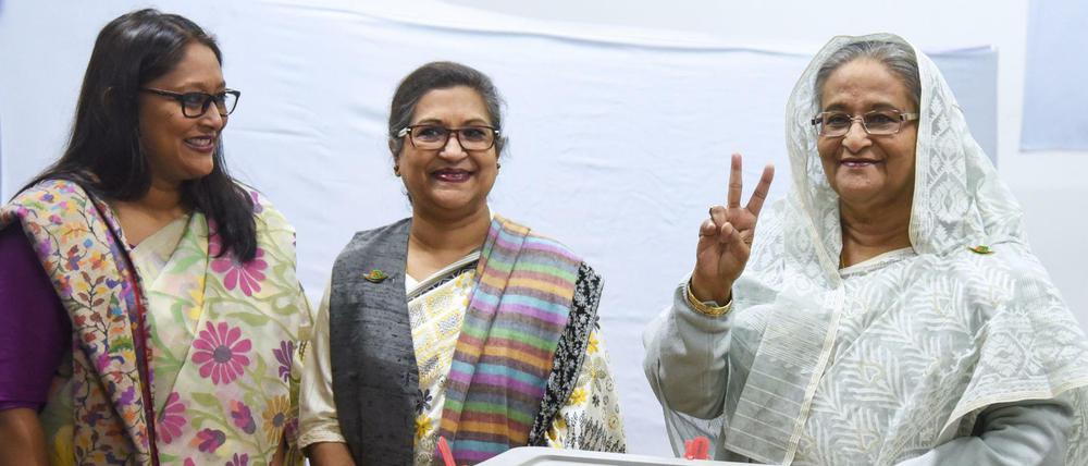 Sheikh Hasina (rechts) zeigt nach ihrer Stimmabgabe das Victory-Symbol.