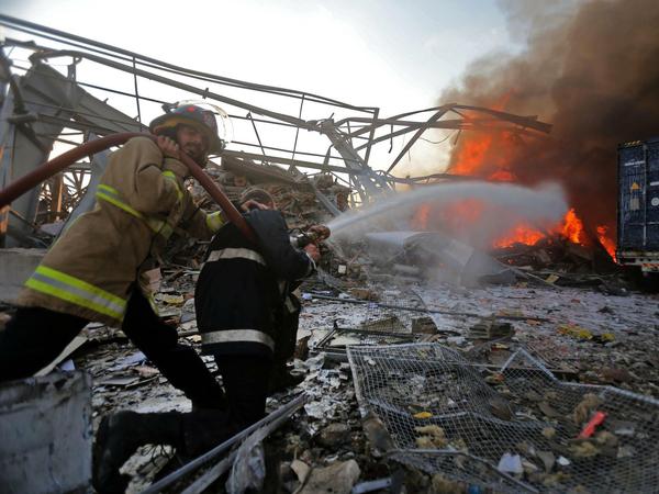 Feuerwehrmänner in Beirut versuchen nach den Explosionen Flammen zu bekämpfen.