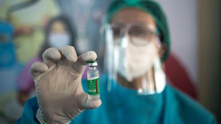 Eine medizinische Mitarbeiterin hält eine Dose des Astrazeneca-Impfstoffes hoch.