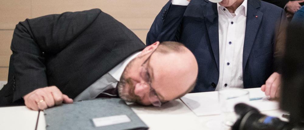 Martin Schulz versucht bei dem Treffen mit Delegierten in Dortmund eine Flasche Wasser unter dem Tisch hervorzuholen. 