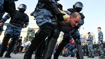 Polizisten nehmen einen Demonstranten fest. 