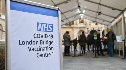 Menschen stehen an einem Corona-Impfzentrum in London an.