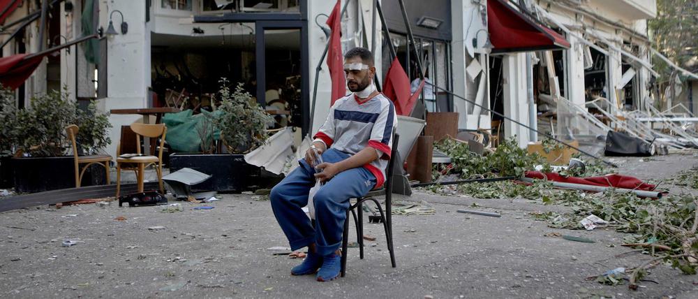 Ein Verletzter vor einem teilweise zerstörten Restaurant im Stadtteil Mar Mikhael nach der Explosion im Hafen.