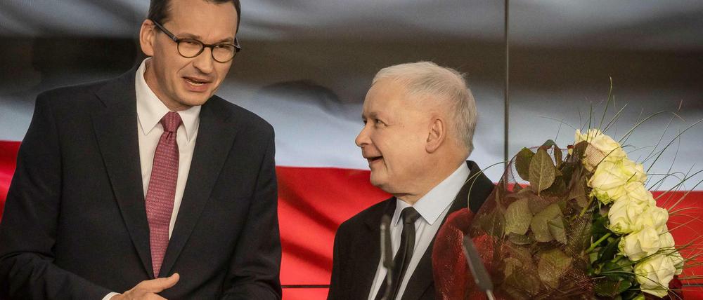 Jaroslaw Kaczynski (r), Vorsitzender der PiS-Partei, und Mateusz Morawiecki, Ministerpräsident von Polen, freuen sich über ihren Wahlsieg.