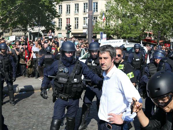Der Linken-Politiker François Ruffin begutachtet die Szenerie bei einer Anti-Macron-Demonstration, wo ein Wagen des Senders "Franceinfo" (im Hintergrund) demoliert wurde.