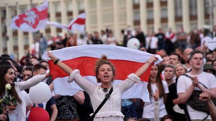 Eine junge Frau demonstriert im August mit Fahne gegen den Diktator Alexander Lukaschenko. 