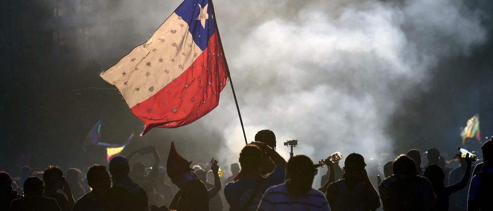 Demonstranten schwingen die chilenische Flagge.