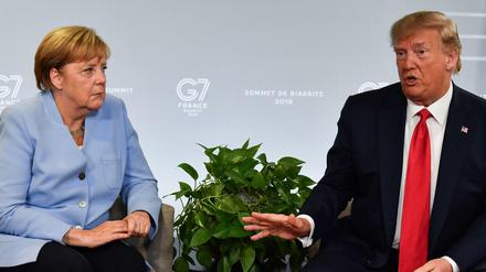 Ein Archivbild von Angela Merkel und Donald Trump beim G7-Gipfel 2019 (Photo by Nicholas Kamm / AFP).