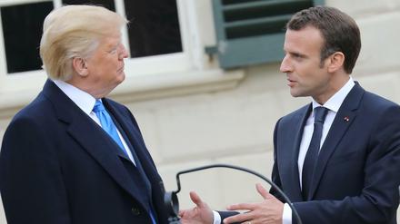 Frankreichs Präsident Macron redet auf Gastgeber Donald Trump ein. 