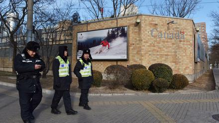 Chinesische Polizisten patrouillieren vor der Botschaft von Kanada in Peking. 