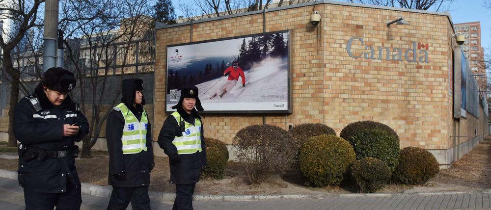 Chinesische Polizisten patrouillieren vor der Botschaft von Kanada in Peking. 