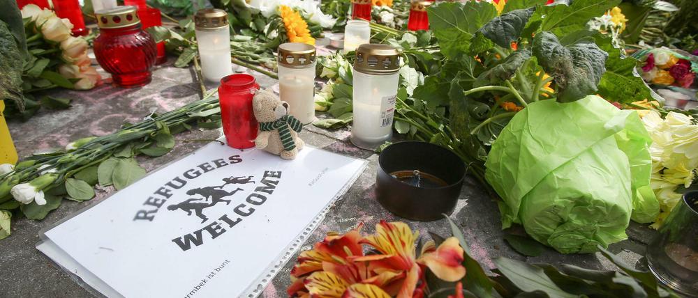 Neben Blumen und Kerzen haben Hamburger ein Schild mit "Flüchtlinge Willkommen, Barmbek ist bunt" am Ort des Angriffs abgelegt. 