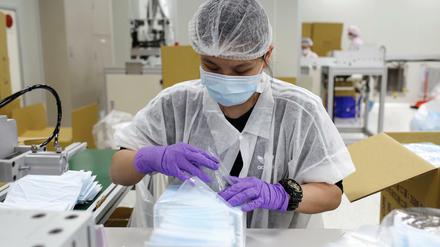 In einer Fabrik in Taiwan werden Schutzmasken verpackt. Eine Million Masken aus Taiwan gingen jetzt nach Deutschland.