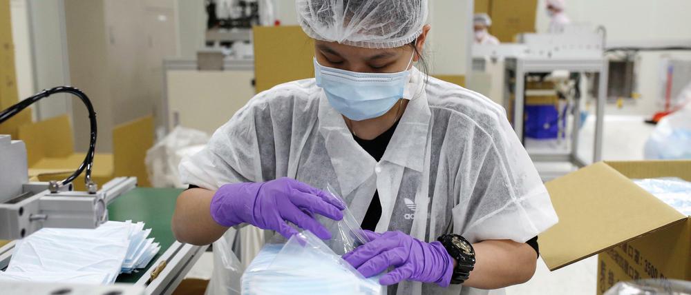 In einer Fabrik in Taiwan werden Schutzmasken verpackt. Eine Million Masken aus Taiwan gingen jetzt nach Deutschland.