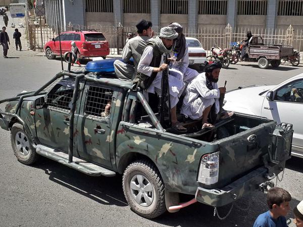 Taliban fahren mit einem erbeuteten Armeefahrzeug durch Kandahar.