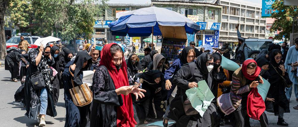 Protestierende Frauen in Kabul flüchten, nachdem Warnschüsse gefallen sind.